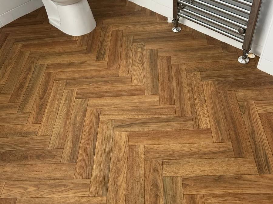 Herringbone wood-effect vinyl tiles fitted in a bathroom